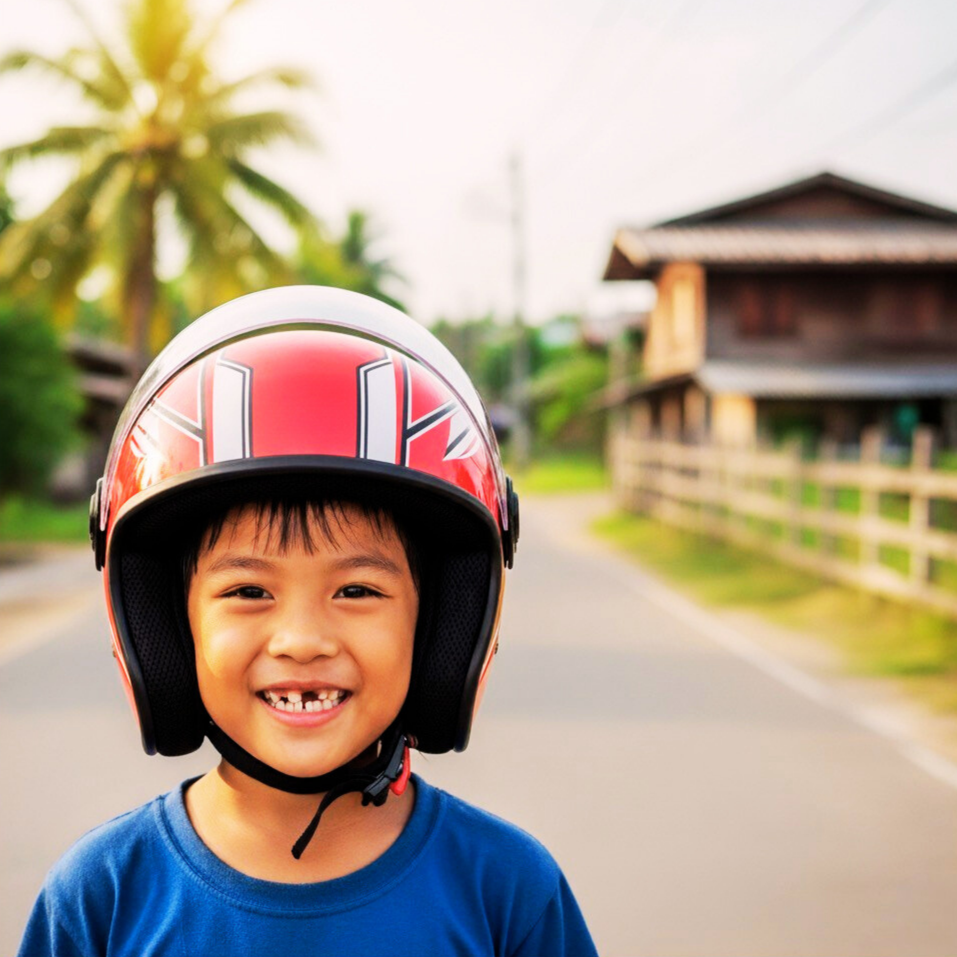 Happy Thai boy smiling while wearing a new motorcycle helmet